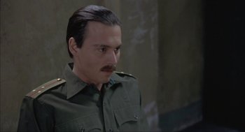 Movie still from “Before Night Falls” (2000), directed by Julian Schnabel – A person wearing a military uniform; Close Up shot, High angle