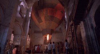 Movie still from “Before Night Falls” (2000), directed by Julian Schnabel – A group of people standing in front of a hot air balloon; Extreme Wide shot, Overhead angle