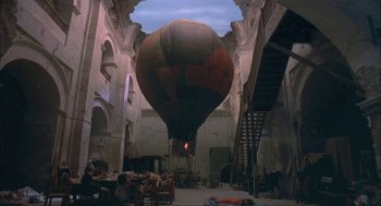 Movie still from “Before Night Falls” (2000), directed by Julian Schnabel – An air balloon is in the middle of an old building; Extreme Wide shot, Overhead angle