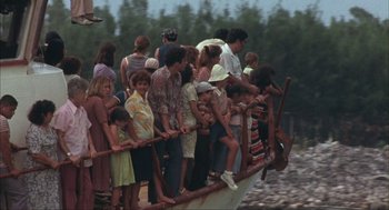 Movie still from “Before Night Falls” (2000), directed by Julian Schnabel – A group of people standing on top of a wooden boat; Extreme Wide shot, High angle