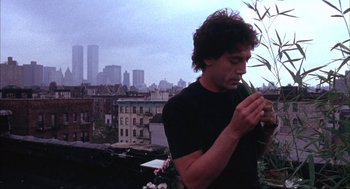 Movie still from “Before Night Falls” (2000), directed by Julian Schnabel – A man standing on top of a building looking at a cell phone; Close Up shot, Low angle