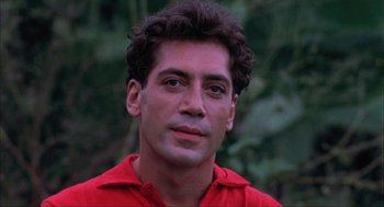 Movie still from “Before Night Falls” (2000), directed by Julian Schnabel – A person wearing a red shirt; Close Up shot, Low angle