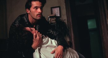 Movie still from “Before Night Falls” (2000), directed by Julian Schnabel – A man and a woman are sitting on a couch; Close Up shot, Low angle