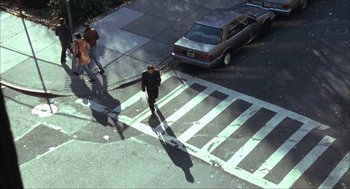 Movie still from “Before Night Falls” (2000), directed by Julian Schnabel – A man walking across a street in a crosswalk; Extreme Wide shot, High angle