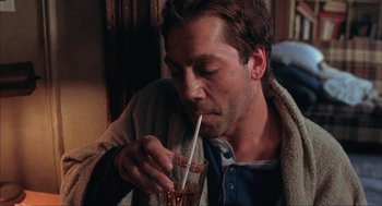 Movie still from “Before Night Falls” (2000), directed by Julian Schnabel – A person drinking a drink from a straw; Close Up shot, High angle