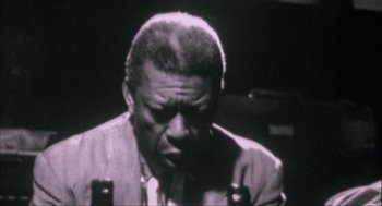 Movie still from “Before Night Falls” (2000), directed by Julian Schnabel – An old black and white photo of a man in a suit; Close Up shot, Low angle