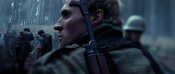 Movie still from “Behind Enemy Lines” (2001), directed by John Moore – A person holding a rifle; Close Up shot, Low angle