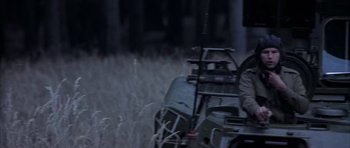 Movie still from “Behind Enemy Lines” (2001), directed by John Moore – A man riding a vehicle through a field at night; Medium shot, Low angle
