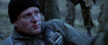 Movie still from “Behind Enemy Lines” (2001), directed by John Moore – A man with a bandage on his face and a bandage on his neck; Close Up shot, High angle