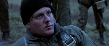 Movie still from “Behind Enemy Lines” (2001), directed by John Moore – A person wearing a jacket and a hat; Close Up shot, Low angle