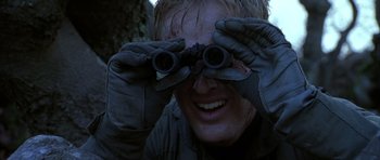 Movie still from “Behind Enemy Lines” (2001), directed by John Moore – A man looking through a pair of binoculars; Close Up shot, Low angle
