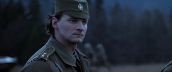 Movie still from “Behind Enemy Lines” (2001), directed by John Moore – A man in a military uniform is standing in front of a group; Close Up shot, Low angle