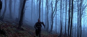 Movie still from “Behind Enemy Lines” (2001), directed by John Moore – A man running through the woods on a foggy day; Wide shot, Low angle