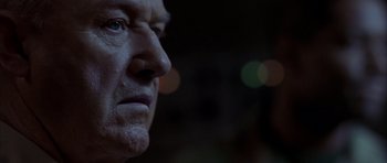 Movie still from “Behind Enemy Lines” (2001), directed by John Moore – An older man's face is lit up by the lights; Close Up shot, Low angle