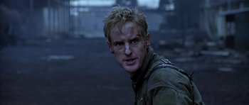 Movie still from “Behind Enemy Lines” (2001), directed by John Moore – A person with a face covered in blood; Close Up shot, Over the shoulder angle