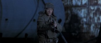 Movie still from “Behind Enemy Lines” (2001), directed by John Moore – A man holding a gun while standing in a room; Medium shot, Low angle