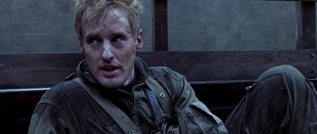 Movie still from “Behind Enemy Lines” (2001), directed by John Moore – A person sitting on a bench; Close Up shot, Over the shoulder angle