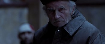 Movie still from “Behind Enemy Lines” (2001), directed by John Moore – An old man with a beard and a hat is looking at the camera; Close Up shot, Over the shoulder angle