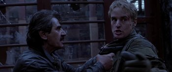 Movie still from “Behind Enemy Lines” (2001), directed by John Moore – A man and a woman holding a gun in front of a building; Close Up shot, Over the shoulder angle