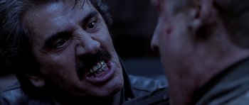 Movie still from “Behind Enemy Lines” (2001), directed by John Moore – A man with a beard and mustache is talking to another man; Close Up shot, Low angle