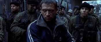 Movie still from “Behind Enemy Lines” (2001), directed by John Moore – A person holding a gun in a crowd; Close Up shot, Low angle