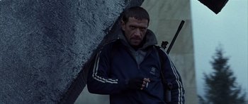 Movie still from “Behind Enemy Lines” (2001), directed by John Moore – A man holding an umbrella while standing in the rain; Medium shot, Low angle