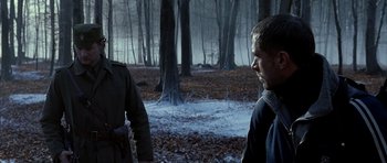 Movie still from “Behind Enemy Lines” (2001), directed by John Moore – Two men in the woods looking at each other; Medium shot, Over the shoulder angle