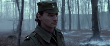 Movie still from “Behind Enemy Lines” (2001), directed by John Moore – A man in a military uniform in the woods; Close Up shot, Low angle