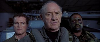Movie still from “Behind Enemy Lines” (2001), directed by John Moore – An older man wearing a black shirt and a black jacket; Close Up shot, Low angle