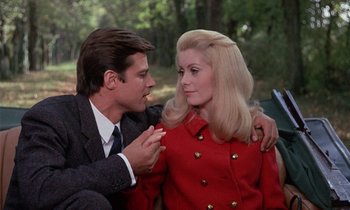 Movie still from “Belle de Jour” (1967), directed by Luis Buñuel – A man and a woman sitting next to each other in a park; Medium shot, Low angle