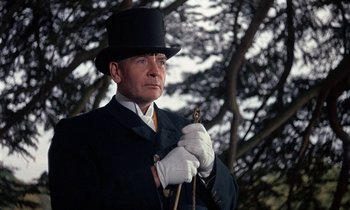 Movie still from “Belle de Jour” (1967), directed by Luis Buñuel – A man in a top hat and white gloves holding a whip; Close Up shot, Low angle