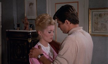 Movie still from “Belle de Jour” (1967), directed by Luis Buñuel – A man and a woman standing next to each other; Medium shot, Over the shoulder angle