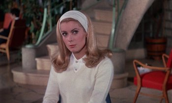 Movie still from “Belle de Jour” (1967), directed by Luis Buñuel – A woman in a white shirt and a white head scarf; Close Up shot, Over the shoulder angle