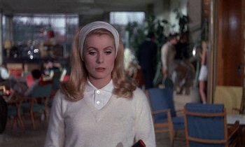 Movie still from “Belle de Jour” (1967), directed by Luis Buñuel – A woman in a white shirt and a white head scarf; Medium shot, Over the shoulder angle