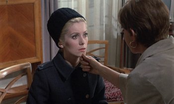 Movie still from “Belle de Jour” (1967), directed by Luis Buñuel – A woman putting lipstick on another woman's face; Close Up shot, Over the shoulder angle