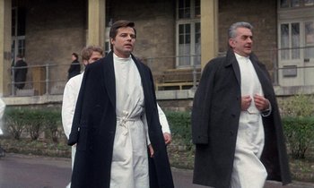 Movie still from “Belle de Jour” (1967), directed by Luis Buñuel – A group of men walking down a street; Medium shot, Low angle