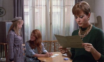 Movie still from “Belle de Jour” (1967), directed by Luis Buñuel – A woman is reading a menu at a restaurant; Medium shot, Over the shoulder angle