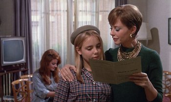 Movie still from “Belle de Jour” (1967), directed by Luis Buñuel – A woman and a young girl are looking at a book; Medium shot, Over the shoulder angle