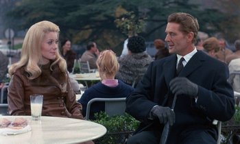 Movie still from “Belle de Jour” (1967), directed by Luis Buñuel – A man and a woman are sitting at a table; Medium shot, Over the shoulder angle