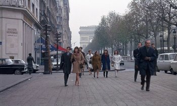 Movie still from “Belle de Jour” (1967), directed by Luis Buñuel – A group of people walking down a street; Wide shot, Low angle