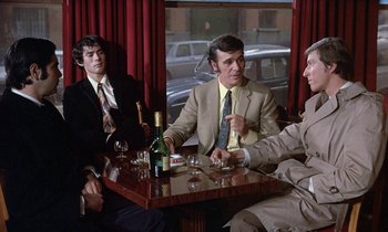 Movie still from “Belle de Jour” (1967), directed by Luis Buñuel – A group of men sitting around a table with wine glasses; Medium shot, High angle