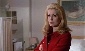 Movie still from “Belle de Jour” (1967), directed by Luis Buñuel – A woman in a red coat standing in front of a mirror; Close Up shot, Over the shoulder angle