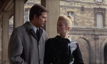 Movie still from “Belle de Jour” (1967), directed by Luis Buñuel – A man and a woman standing next to each other; Medium shot, Low angle