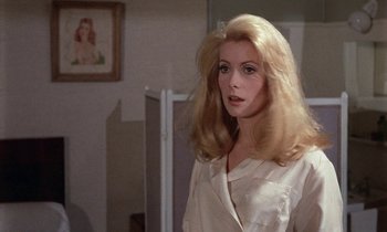 Movie still from “Belle de Jour” (1967), directed by Luis Buñuel – A woman with long blonde hair standing in front of a bathroom mirror; Close Up shot, Over the shoulder angle