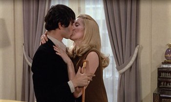 Movie still from “Belle de Jour” (1967), directed by Luis Buñuel – A man and a woman kissing in front of a window; Medium shot, Over the shoulder angle