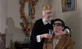 Movie still from “Belle de Jour” (1967), directed by Luis Buñuel – A man and a woman are holding a wine glass; Medium shot, Over the shoulder angle