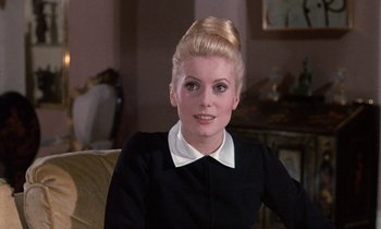 Movie still from “Belle de Jour” (1967), directed by Luis Buñuel – A woman in a black dress and white collar; Close Up shot, Over the shoulder angle
