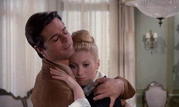 Movie still from “Belle de Jour” (1967), directed by Luis Buñuel – A man and a woman hugging each other in front of a window; Close Up shot, High angle