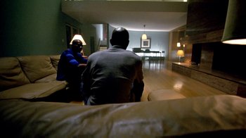 Movie still from “Belly” (1998), directed by Hype Williams – Two people sitting on a couch in a living room; Wide shot, High angle
