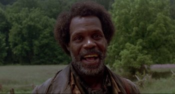 Movie still from “Beloved” (1998), directed by Jonathan Demme – An older man with a beard smiling for the camera; Close Up shot, Low angle